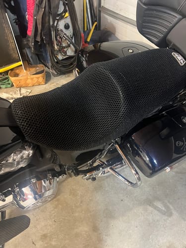 Customer's black mesh Wind Rider Seat Cover installed snugly on a motorcycle seat in a garage.