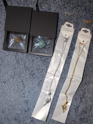 Customer's Dice Necklace purchase with two dice in gift boxes and separate silver and gold chains still in their packaging.