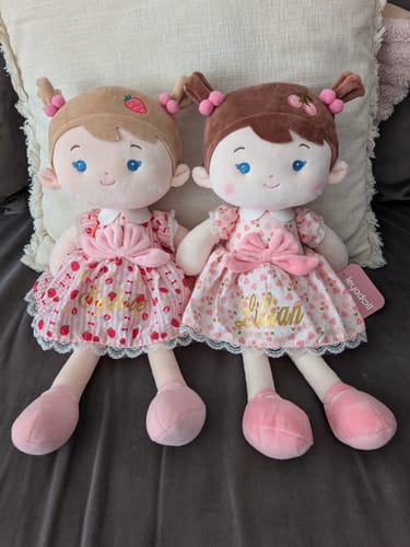Customer's two personalized Cherry Girl dolls with different hair colors and pink patterned dresses, sitting side-by-side.