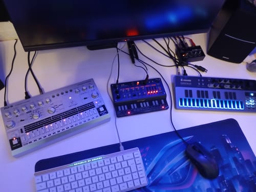 Der Donner Essential B1 Synthesizer eines Rezensenten mit leuchtenden Tasten, als Teil eines Setups mit anderen analogen Geräten.