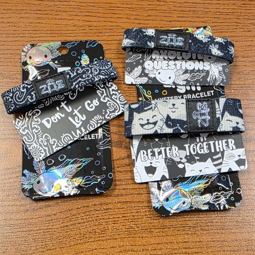 Customer's four Emerging Light Add-On bracelets in their original packaging, displaying various black and white designs.