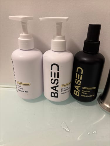 Reviewer's bottle of Curl Cream shown with other Based hair products on a counter.