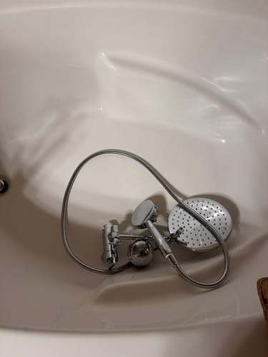 Customer's removed 3-Spray Dual Shower Head assembly resting in a white bathtub.