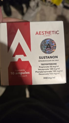 Cliente mostrando la caja sellada de Sustanon de Aesthetic Labs, con un holograma de autenticidad.