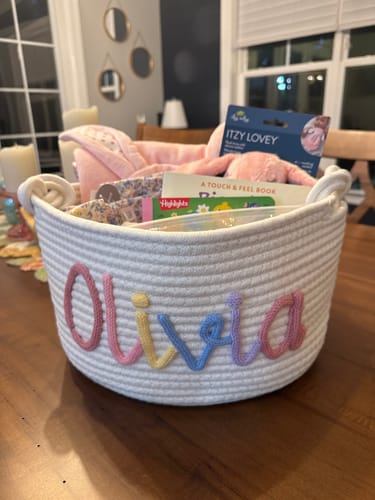Reviewer's personalized woven basket with the name 'Olivia' in colorful yarn, filled with Easter gifts.
