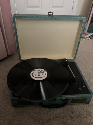 Customer's custom vinyl record with a Hello Kitty label placed on a portable teal record player.