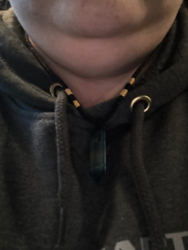 Close-up: Reviewer wearing the Natural Fluorite Necklace with a dark hoodie.