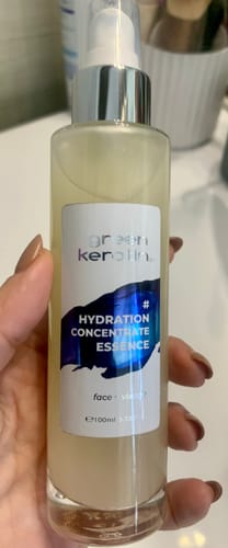 Client tenant le flacon pompe transparent de l'essence HYDRATION CONCENTRATE.