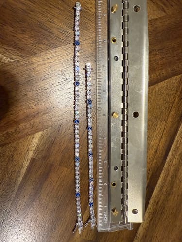Customer showing two 'Evil eye' Tennis bracelets of different lengths next to a ruler to illustrate a sizing issue.