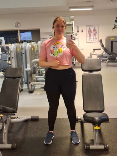 Reviewer in a gym wearing the pink Curl Bears Women’s Loose Crop Top.