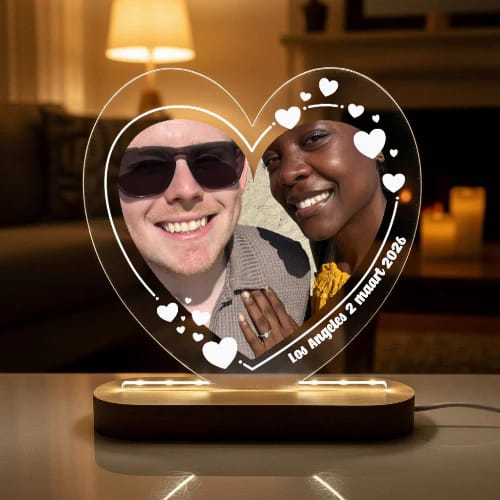 Klant's gepersonaliseerde hartvormige ledlamp, verlicht en met een foto van een stel erop.