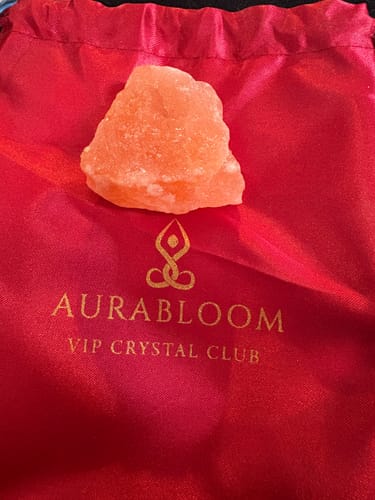 Reviewer's Himalayan rock crystal from the VIP Crystal Club, shown on a red branded pouch.