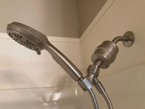 Customer's metal Shower Head Filter installed between the shower arm and a handheld shower head.