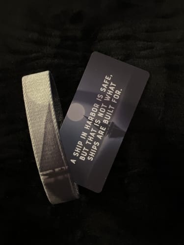 Customer's 'Ship in Harbor' bracelet and matching collector's card displayed on a soft black surface.