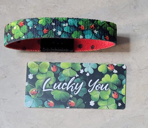 Customer's Lucky You Bracelet with a green clover and ladybug pattern shown next to the matching product card.