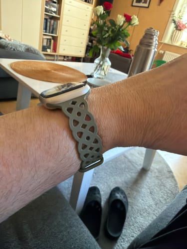 Customer's wrist showing the green Calla Silicone Strap with its lace-inspired cutout design, worn with an Apple Watch.