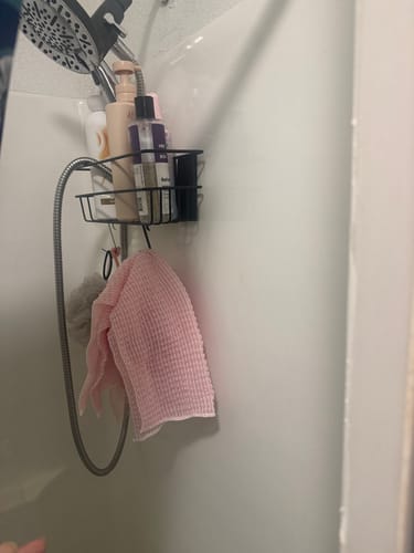 Reviewer's bottle of Refresh Intimate Body Wash in a black wire caddy hanging in a shower.