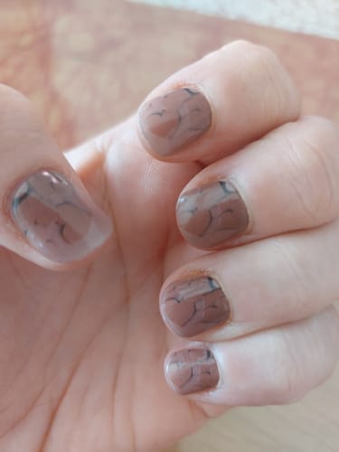 Kundin zeigt ihre 'Neutral Love' UV-Gel-Nägel mit Herzdetails nach einer Woche Tragezeit.