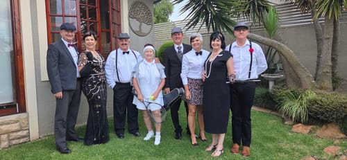 Customers dressed as 1920s characters for the Murder Mystery Game, posing together in a garden.