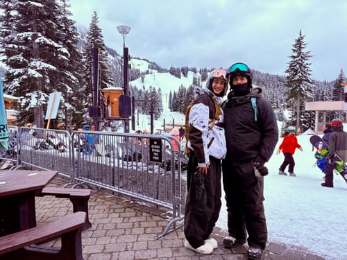 Reviewer in the color-block Insulated Snow Anorak, posing with a friend at a snowy ski resort.