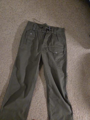 A customer's olive Gurkha Bermuda Pants laid out on a carpeted floor, showing the high waist and buckle straps.