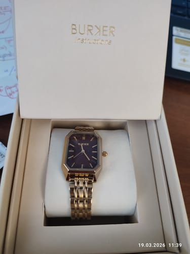 Customer's Isabell Gold Burgundy watch with a rectangular face, shown inside its original packaging.