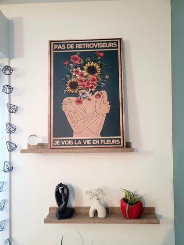 Avis d'un client : l'affiche encadrée 'Pas de rétroviseurs' posée sur une étagère murale en bois.