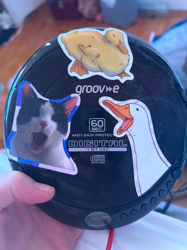 Customer holding their personalized Groov-e Portable CD Player covered in fun stickers.