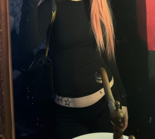 Reviewer in a mirror selfie wearing the black Seamless LowRise Leggings, showing their very low fit on the hips.
