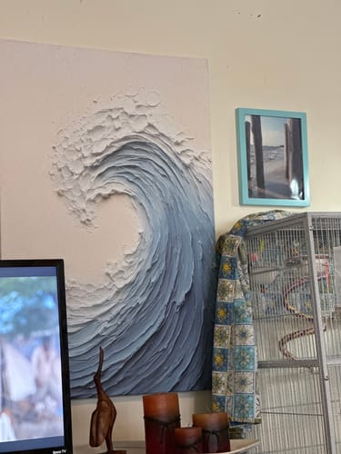 Customer's textured wave wall art with vibrant blue colors, hanging on a wall.