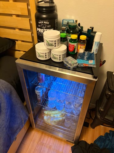 Customer's three tubs of D-BLOAT stacked on a mini-fridge among other health supplements.