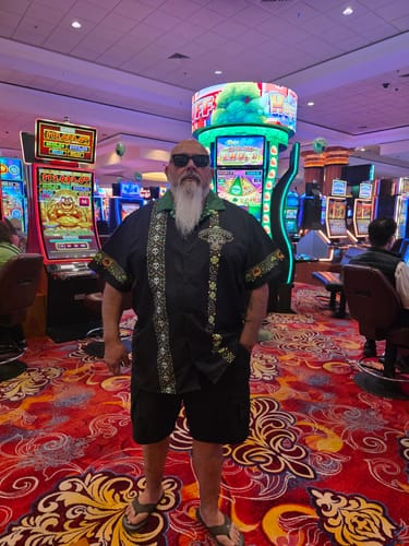 Reviewer wearing the black San Patricio Calavera Guayabera shirt with shorts in a busy casino.