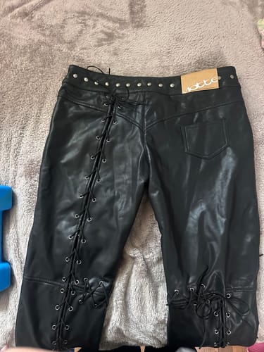 Customer's black Vice Pant laid out, showing the lace-up leg details and studded waistband.