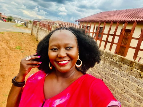 Close-up of a reviewer smiling, wearing her vibrant pink Buttoned V-Neck Dress outdoors.