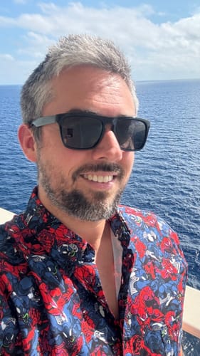 Reviewer smiling outdoors while wearing the Marvel “Bad Hosts” shirt, showing its bold, colorful comic book pattern.