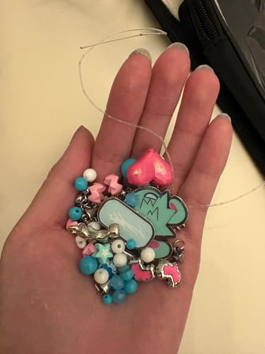 Customer holding the colorful charms and beads from the Alien Stage Rabbit Series phone chain in their palm.