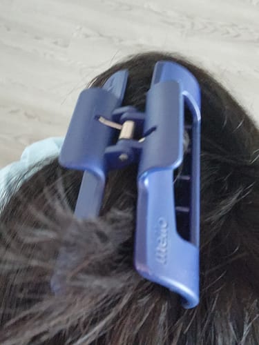 Close-up of a customer wearing a blue Mello hair clip in their dark hair.