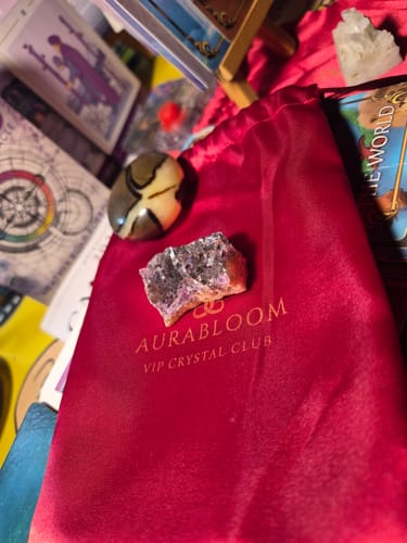 Customer's amethyst cluster and another stone on top of the branded red pouch from the VIP Crystal Club.