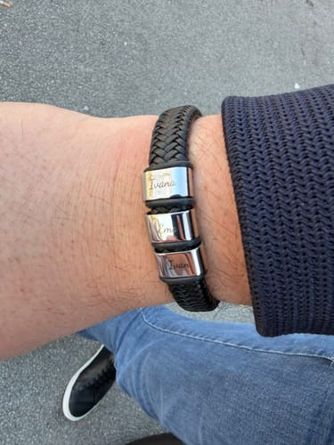 Customer wearing the braided black Viking bracelet on their wrist, showing three personalized stainless steel beads.