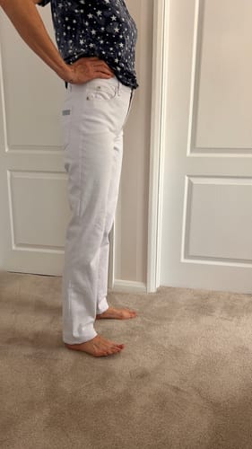 Reviewer showing a side view of white jeans made from the stretch denim fabric.