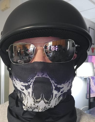 Customer wearing the flat black SOA beanie helmet with sunglasses and a face mask, showing its low-profile fit.