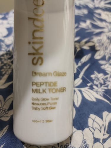 Close-up of the reviewer's Dream Glaze Peptide Milk Toner bottle, showing the gold text on the label.