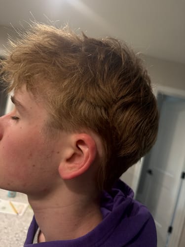 Reviewer shows their son's hair styled with Texture & Hold Duo, which is holding its shape after a long day.