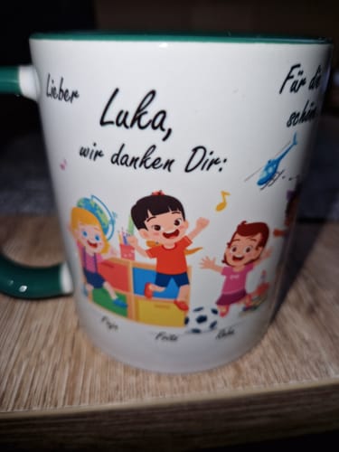 Nahaufnahme der personalisierten Tasse für einen Erzieher namens Luka, mit bunten Illustrationen von Kindern.