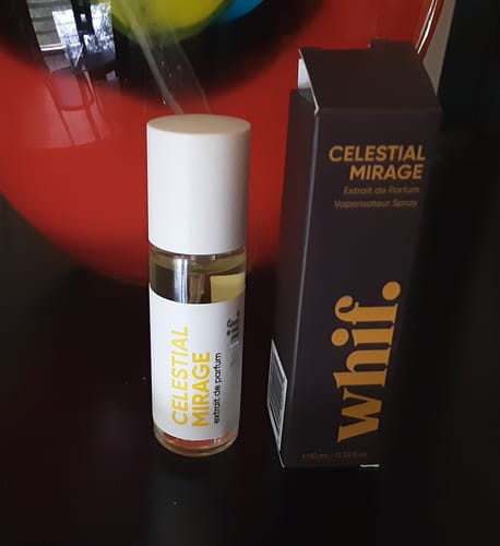 Customer's Celestial Mirage perfume bottle with its white label next to the black product box.