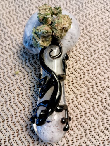 Reviewer's fresh Blue Dream buds in a decorative white and black glass pipe.