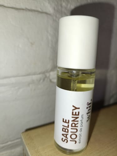 Customer's bottle of Sable Journey perfume, a clear glass cylinder with a white label and cap.
