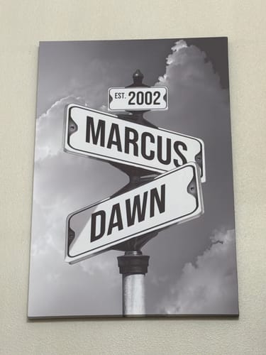 Customer's black-and-white COUPLES DATE OF LOVE canvas showing street signs personalized with 'Marcus,' 'Dawn,' and 'EST. 2002'.