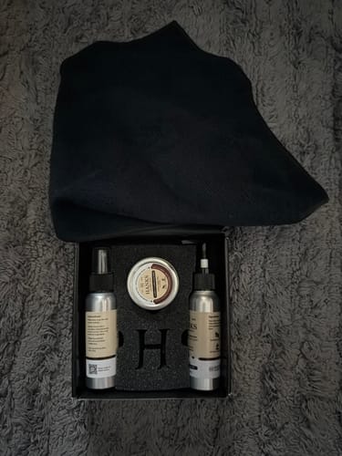 Customer's open Leather Preserve Kit, showing the two bottles, balm tin, and black cloth inside the box.