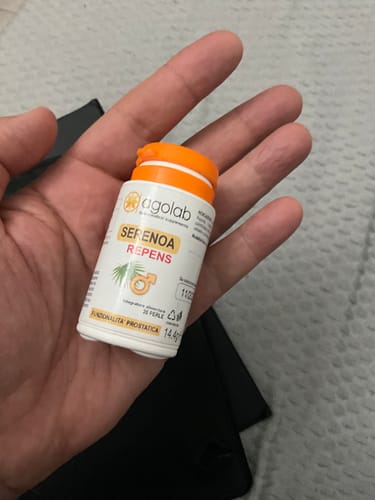 Cliente che tiene nel palmo della mano un piccolo flacone di Serenoa Repens.